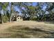 Expansive backyard with mature trees offering ample space, with outbuildings and privacy fencing on property line at 1042 Chambers Ln, Mount Pleasant, SC 29464