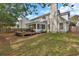 Backyard view featuring wooden deck, enclosed sunroom, and fenced yard at 105 Carter Dr, Goose Creek, SC 29445
