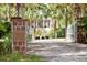 Driveway entrance with decorative brick pillars, iron gates, mature landscaping and a view of the home at 1105 Fort Lamar Rd, James Island, SC 29412