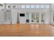 Bright living room with hardwood floors, built-in shelving, transom windows, and access to the pool at 1105 Fort Lamar Rd, James Island, SC 29412
