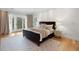 Serene main bedroom with balcony access, hardwood floors, and a view of the landscaped backyard at 1105 Fort Lamar Rd, James Island, SC 29412