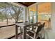 Covered porch with a dining table and chairs and views of the surrounding landscape and glimpses of the water at 1105 Fort Lamar Rd, James Island, SC 29412