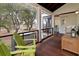 A covered porch with wood floors, ample seating, and views of the surrounding trees and marshland at 1105 Fort Lamar Rd, James Island, SC 29412