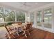 Relaxing screened porch with wood flooring, ceiling fan, and dining table, perfect for outdoor meals at 1105 Fort Lamar Rd, James Island, SC 29412