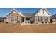 Charming single-story home featuring a stone facade, landscaped front yard, and covered porch at 121 Lakelyn Rd, Moncks Corner, SC 29461