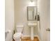 Cozy powder room with a pedestal sink, decorative mirror, and wood-look flooring at 1305 Discovery Dr, Ladson, SC 29456
