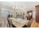 Dining room with a wood table and chairs, with light from a view of the living room at 1305 Discovery Dr, Ladson, SC 29456