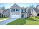 Well-kept two-story home with a two-car garage, manicured lawn, and stylish gray exterior at 1305 Discovery Dr, Ladson, SC 29456