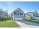 Lovely two-story home with a convenient two-car garage, lush green lawn, and appealing gray exterior at 1305 Discovery Dr, Ladson, SC 29456