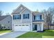 Beautiful two-story home showcasing a two-car garage, tidy landscaping, and eye-catching gray siding at 1305 Discovery Dr, Ladson, SC 29456