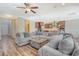 Open-concept living room featuring a large gray sofa and a view into the modern kitchen at 1305 Discovery Dr, Ladson, SC 29456