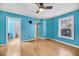 A light blue bedroom features an ensuite bathroom, window with blinds, and wood-look floors at 1402 Camp Rd # 8B, Charleston, SC 29412