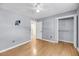 This bedroom features gray walls, wood floors, a ceiling fan, a closet, and a door at 1402 Camp Rd # 8B, Charleston, SC 29412