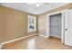 This bedroom features neutral walls, wood floors, a ceiling fan, a window, and a closet with white doors at 1402 Camp Rd # 8B, Charleston, SC 29412