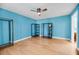 Spacious bedroom features a ceiling fan, blue walls, and unique wooden closet fixtures at 1402 Camp Rd # 8B, Charleston, SC 29412