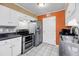 Traditional kitchen with white cabinetry, stainless steel appliances, and an orange accent wall at 1402 Camp Rd # 8B, Charleston, SC 29412