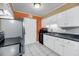 Traditional kitchen with white cabinetry, stainless steel appliances, and an orange accent wall at 1402 Camp Rd # 8B, Charleston, SC 29412