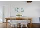 Dining area showcases a wooden table, white chairs, and oyster artwork against a white wall at 1589 Kentwood Cir, Charleston, SC 29412