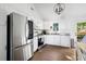 Modern kitchen with stainless steel appliances, white cabinets, granite countertops, and hardwood floors at 1589 Kentwood Cir, Charleston, SC 29412