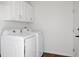 Functional laundry room with white washer and dryer, white cabinets, and hardwood floors at 1589 Kentwood Cir, Charleston, SC 29412
