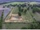 An aerial perspective showing the property has farm land, mature trees, an excavated pond and outbuildings at 1758 Mendel Rivers Rd, Saint Stephen, SC 29479