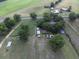 This aerial shot reveals a property featuring outbuildings, gardens, a pool, mature trees, and road access at 1758 Mendel Rivers Rd, Saint Stephen, SC 29479