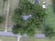An aerial view of a charming house surrounded by mature trees, situated on a spacious lot with an adjacent country road at 1758 Mendel Rivers Rd, Saint Stephen, SC 29479