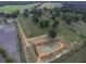 A pond is the focal point of this aerial shot, enhanced by lush surroundings and neighboring farmland at 1758 Mendel Rivers Rd, Saint Stephen, SC 29479