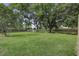 Spacious backyard with a wooden fence and ample green space, partially shaded by mature trees at 1758 Mendel Rivers Rd, Saint Stephen, SC 29479