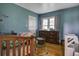 Blue bedroom with a wooden crib, dresser, and wood floors at 1758 Mendel Rivers Rd, Saint Stephen, SC 29479