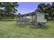 Image features a quaint chicken coop in a grassy yard with mature trees, providing a rural charm at 1758 Mendel Rivers Rd, Saint Stephen, SC 29479