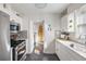 Updated kitchen with stainless steel appliances, subway tile backsplash, and views to adjacent hallway with a surfboard at 18 Sothel Ave, Charleston, SC 29407