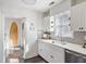 White kitchen featuring gray backsplash, stainless steel appliances, and views to adjacent hallway with a surfboard at 18 Sothel Ave, Charleston, SC 29407
