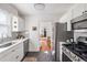 Well-lit kitchen featuring stainless steel appliances, white cabinets, and tile backsplash at 18 Sothel Ave, Charleston, SC 29407
