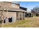 Backyard view featuring a screened porch, brick facade, green lawn, and central air conditioning unit at 1860 Mepkin Rd # H1, Charleston, SC 29407