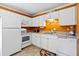 Efficient kitchen featuring white appliances and cabinetry against a striking orange wall at 1860 Mepkin Rd # H1, Charleston, SC 29407