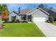 Traditional-style home featuring gray siding, an attached garage, and a lush green lawn at 240 Gazania Way, Charleston, SC 29414