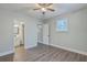 Bedroom features wood grain floors, ceiling fan, bright window and doorway to bathroom and closet at 2673 Olympia Ave, North Charleston, SC 29405