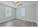 Bedroom features wood grain floors, neutral walls, ceiling fan, and two bright windows at 2673 Olympia Ave, North Charleston, SC 29405