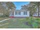 Charming exterior view of home with solar panels, blue shutters, and a screened-in front porch at 2673 Olympia Ave, North Charleston, SC 29405