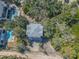 An aerial view shows a house with pools nearby, all surrounded by trees at 2710 Laroche St, Edisto Beach, SC 29438