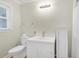 Clean and functional bathroom with a white vanity, toilet, and cabinet, complemented by a window for natural light at 2710 Laroche St, Edisto Beach, SC 29438