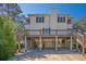Inviting beach house on stilts with stairs leading to a charming porch and a peek at the covered parking area at 2710 Laroche St, Edisto Beach, SC 29438