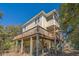 Exterior of coastal home featuring a wrap around deck, covered porch, and mature trees at 2710 Laroche St, Edisto Beach, SC 29438