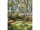 Serene backyard featuring a stone path, lush greenery, and mature trees at 2863 Jasper Blvd, Sullivans Island, SC 29482