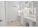 Bright white bathroom featuring double pedestal sinks, wainscoting, and a large window at 2863 Jasper Blvd, Sullivans Island, SC 29482