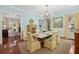 Elegant dining room with a marble table, chandelier, and yellow cushioned chairs at 2863 Jasper Blvd, Sullivans Island, SC 29482