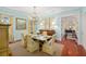 Bright dining room with a marble table, chandelier, and yellow cushioned chairs at 2863 Jasper Blvd, Sullivans Island, SC 29482