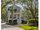 Elegant two-story house featuring a classic design, lush landscaping, and a well-kept lawn at 2863 Jasper Blvd, Sullivans Island, SC 29482