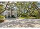 Beautiful two-story house with manicured lawn, palm trees, and a charming coastal design at 2863 Jasper Blvd, Sullivans Island, SC 29482